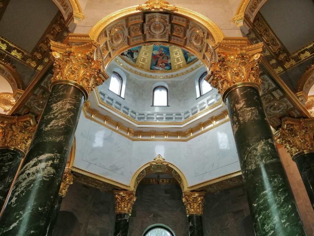 Luxury decorative plaster gilding applied to an ornate frame, demonstrating professional gold leaf finishing in an interior setting