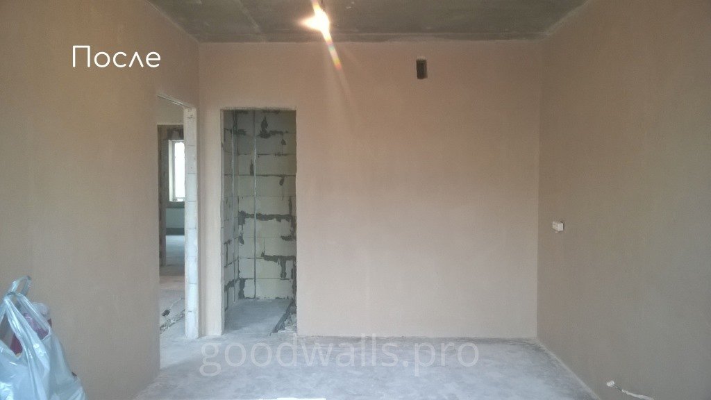Two plasterers working on internal walls beside a plastering machine