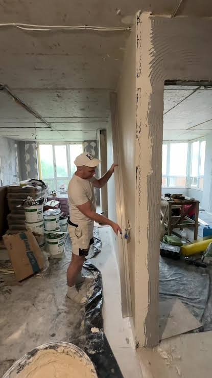 Hallway with newly plastered walls and unfinished flooring